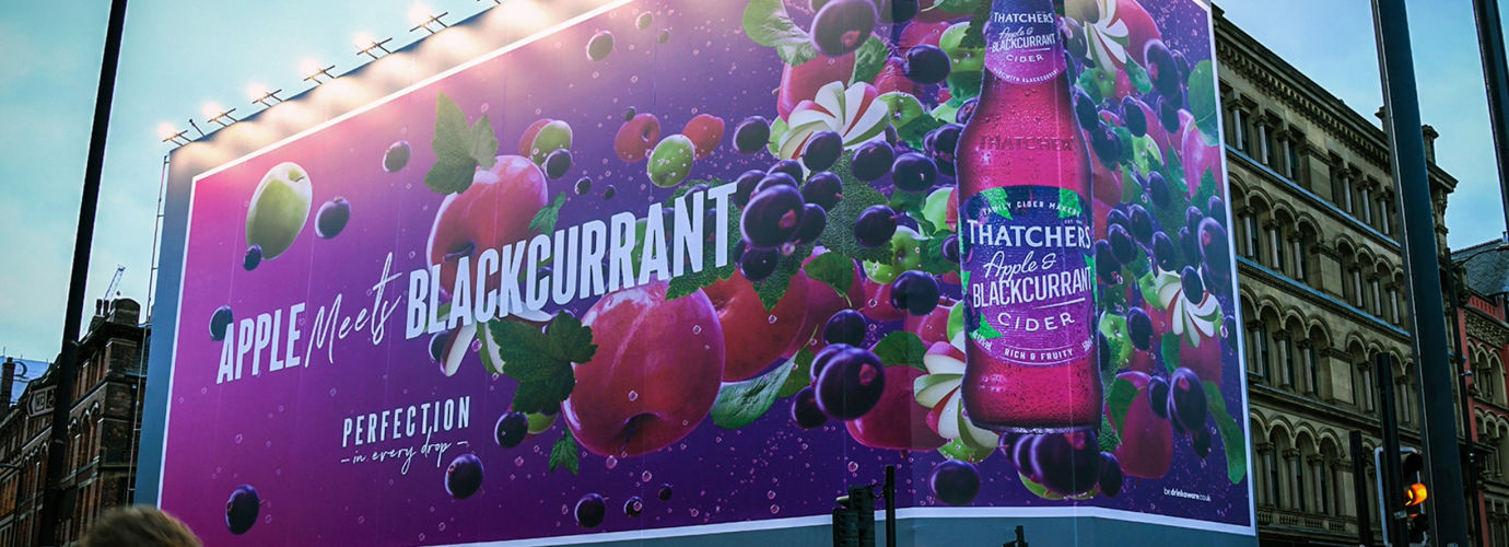 Photograph of large Thatchers Apple and Blackcurrant outdoor advertisement, covering a city corner block.