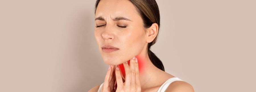 Image of a woman holding her throat and looking in pain